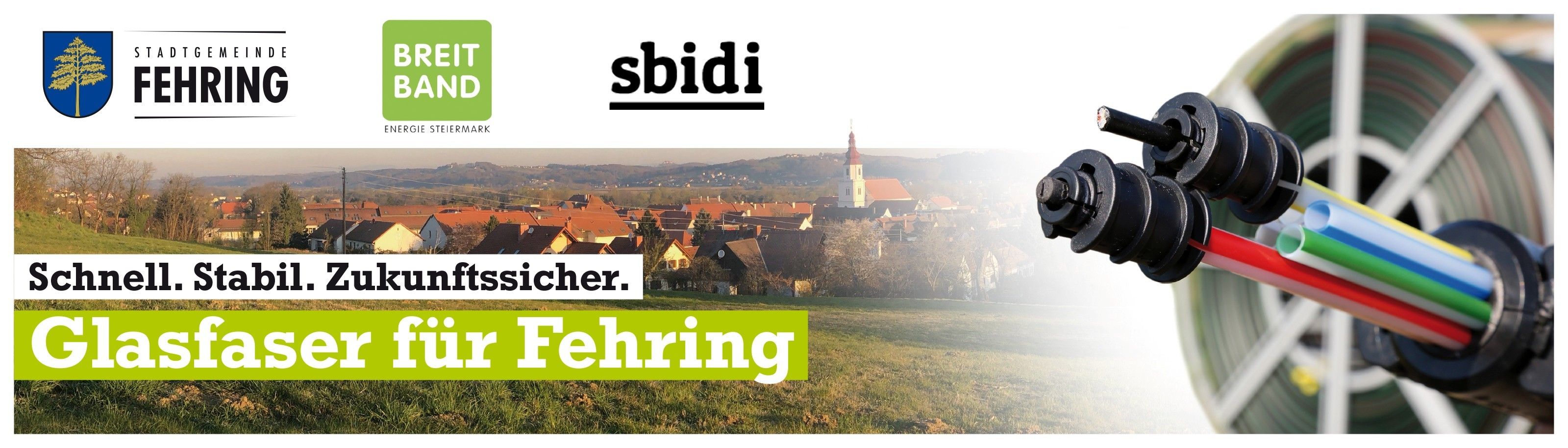 Eine Luftaufnahme einer Stadt mit roten Dächern und einer weißen Kirche in der Ferne. Die Stadt ist von Bäumen und Gras umgeben. Das Bild ist mit dem Text 'sbidi' und 'ehring' überlagert.