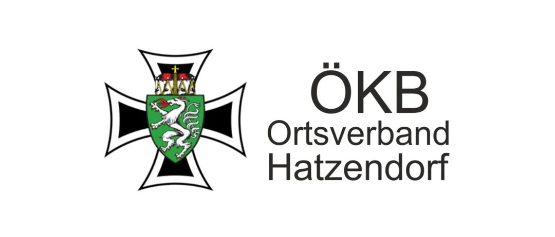Ein weißer Schild mit einem schwarzen Kreuz und einem grünen Emblem eines Vogels mit roten und weißen Elementen in der Mitte.