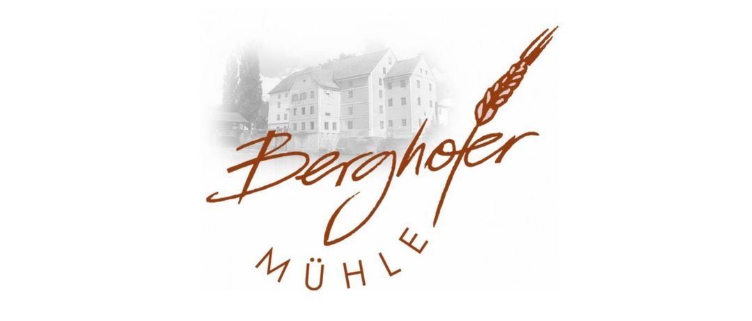Das Logo für Berghofer Mühle wird mit einem großen Gebäude im Hintergrund angezeigt. Das Gebäude ist weiß mit mehreren Fenstern, und ein Baum ist links sichtbar.