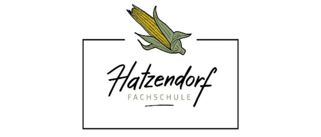 Das Logo der Hatzendorf Fachschule zeigt einen stilisierten Maiskolben mit grünen Blättern und einem schwarzen Rand. Der Text 'Hatzendorf Fachschule' ist in einer kursiven Schrift geschrieben.