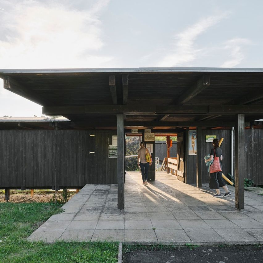 Bild enthält, Outdoors, Shelter, Person, Interior Design, Bus Stop, Shoe, Wood, Handbag, Shorts, Patio
