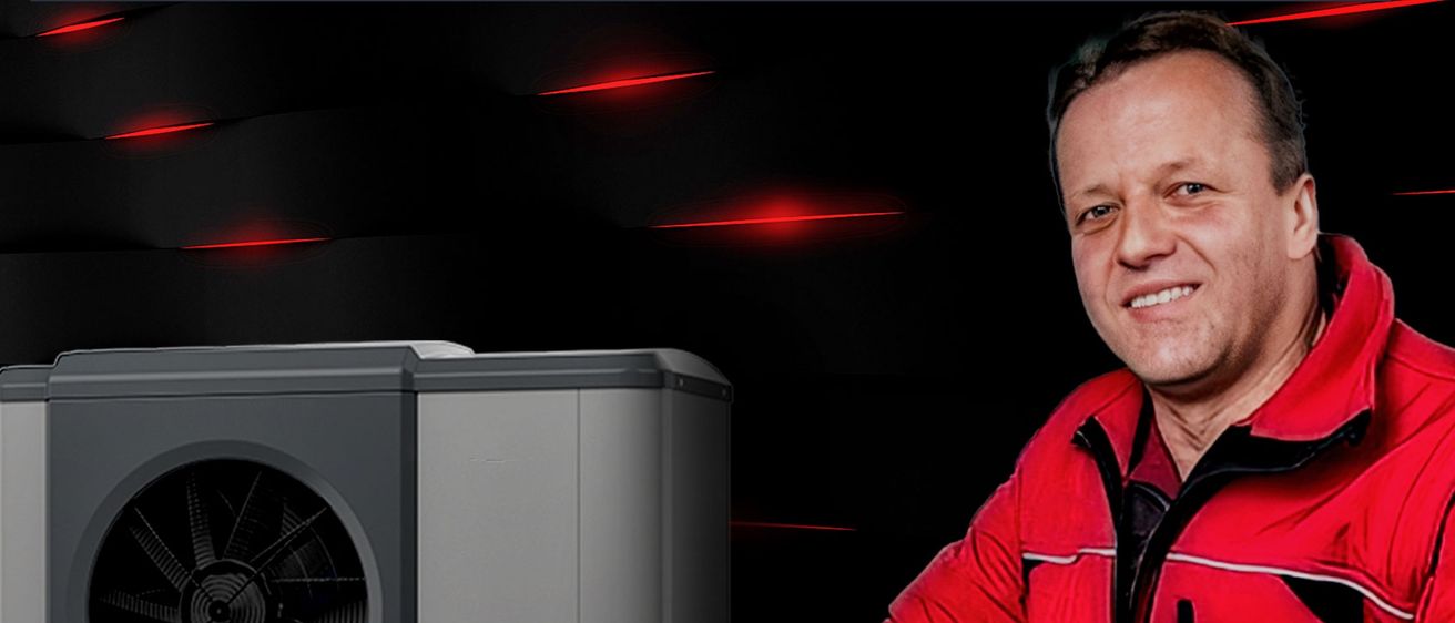 Ein Mann in einem roten Mantel hält eine Fernbedienung in der Hand und steht neben einem grau-weißen Gerät mit einem Lüfter an der Seite.