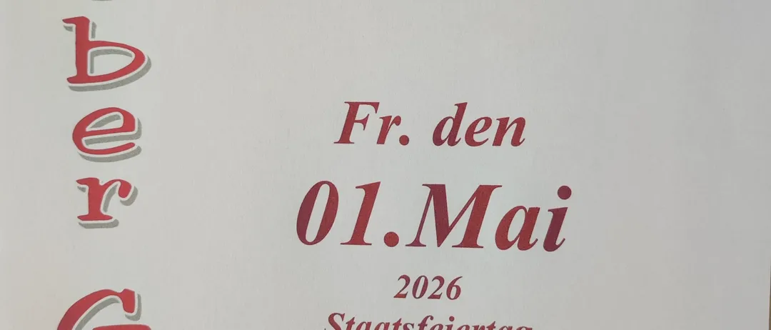 Ein Schild in rotem Schriftzug auf weißem Hintergrund lautet 'Lieber Gast Wir haben am Fr. den 01.Mai 2026 Staatsfeiertag geschlossen.' Das Datum ist der 1. Mai 2026.