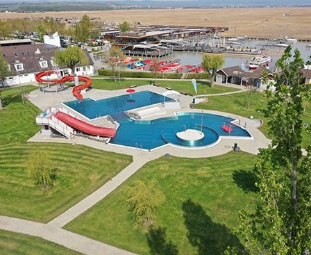 Eine Draufsicht auf einen Wasserpark mit Pool, Rutsche und umliegenden Gebäuden.