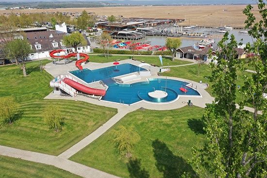 Eine Draufsicht auf einen Wasserpark mit Pool, Rutsche und umliegenden Gebäuden.