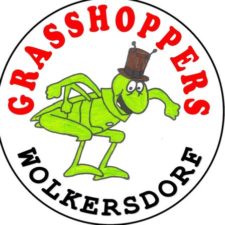 Das kreisförmige Logo zeigt eine grüne Heuschrecke, die einen braunen Topfhut trägt. Die Worte 'GRASSHOPPERS' sind in Rot um den Rand herum geschrieben. Unten steht 'WOLKERSDORF' in Schwarz geschrieben.