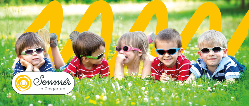 Drei Kinder liegen auf einer Wiese und tragen Sonnenbrillen. Das Mädchen trägt rosa Gläser, während die Jungen grün und blau tragen. Sie lächeln und schauen auf etwas vor ihnen.