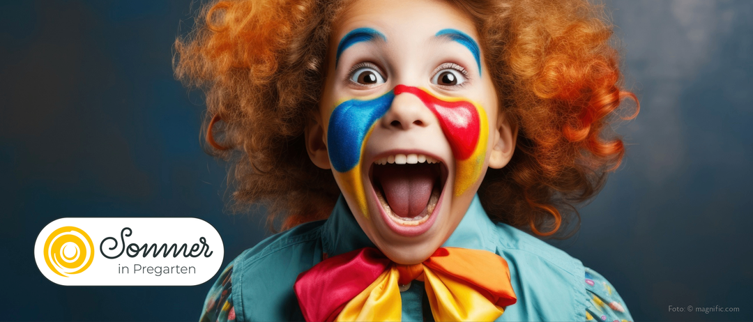 Ein Kind, das als Clown verkleidet ist, mit mehrfarbiger Schminke im Gesicht, öffnet den Mund weit.