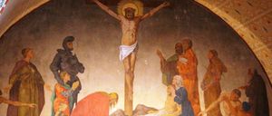 Ein Gemälde zeigt die Kreuzigung Jesu, mit Figuren wie Maria und anderen um das Kreuz herum.