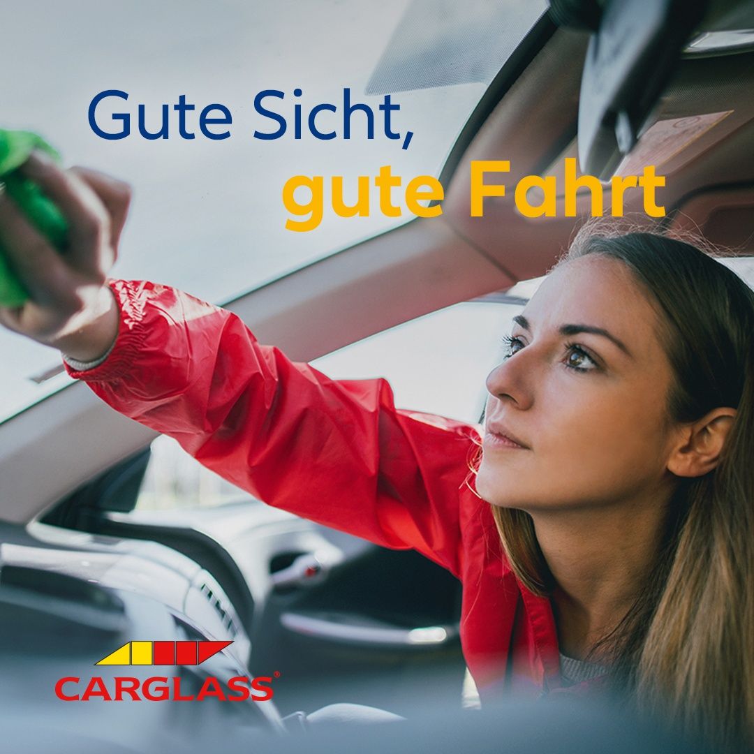 A woman in a red jacket is cleaning a car window with a green cloth. The text reads 'Good sight, good drive.' Below, the Carglass logo is visible.