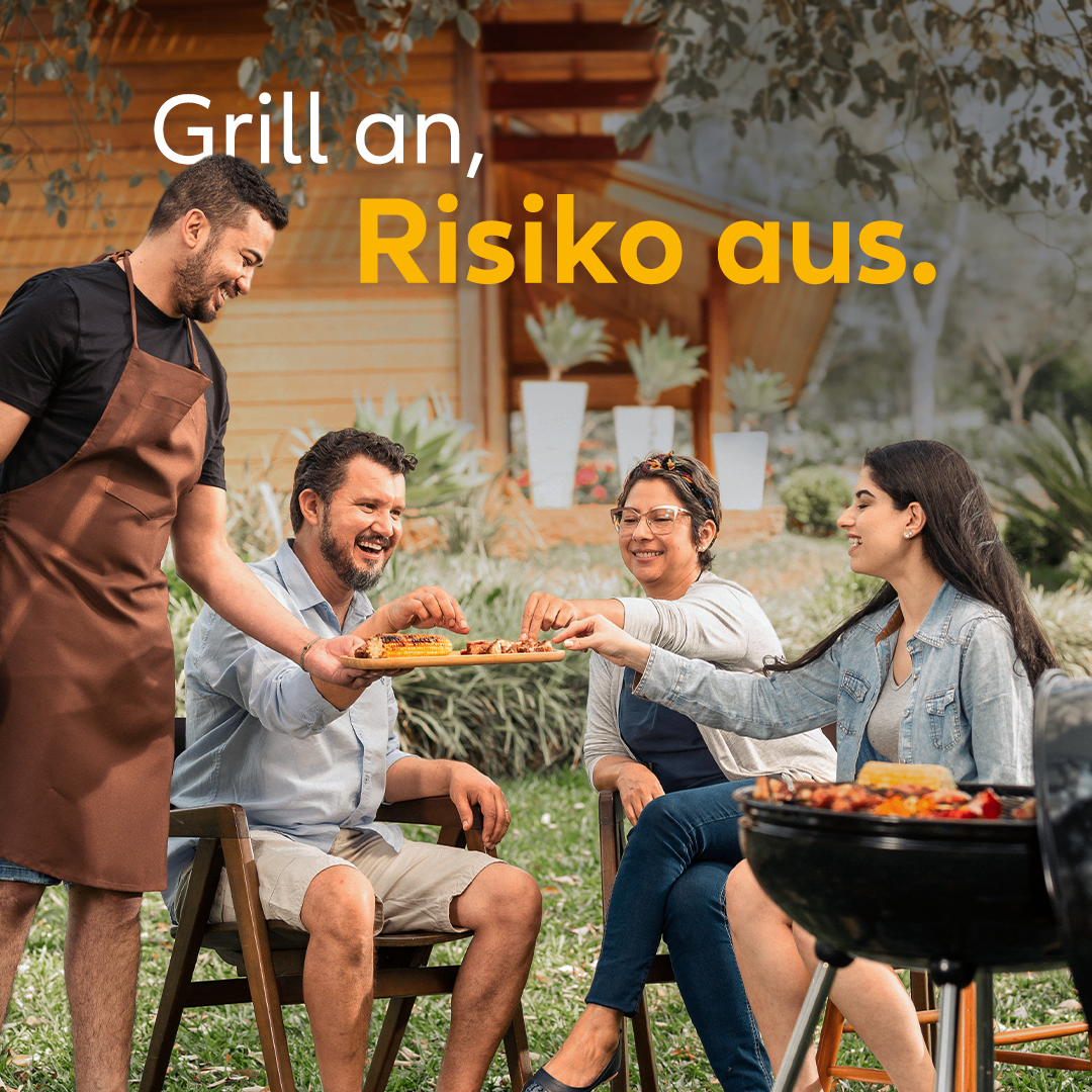 Eine Gruppe von Menschen genießt ein Grillfest im Garten. Ein Mann in einer Schürze serviert einer Frau auf einem Stuhl Essen. Eine andere Frau hält einen Teller mit Essen. Der Text 'Grill an, Risiko aus' steht oben.