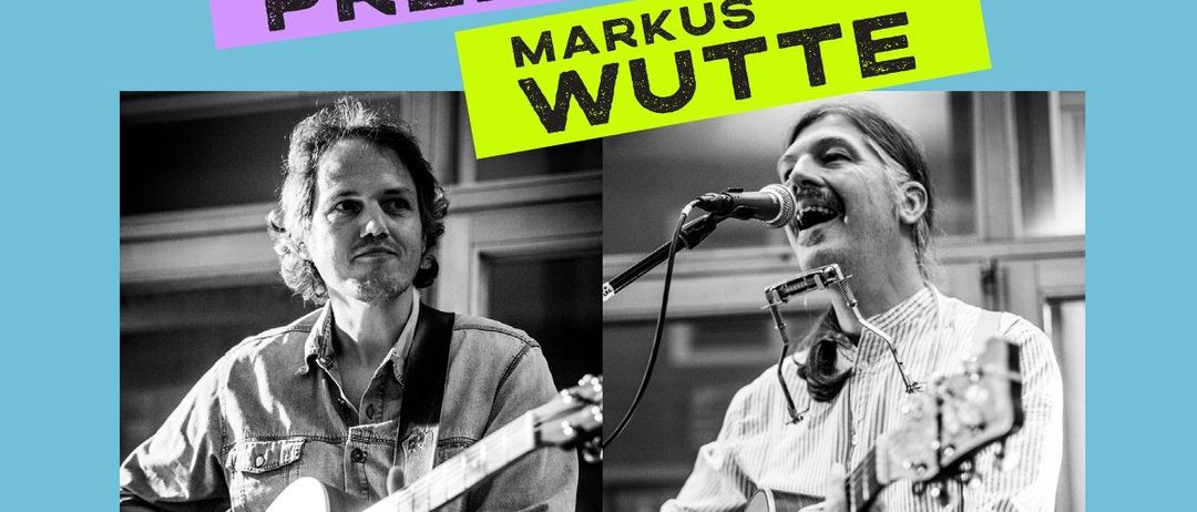 Schwarz-Weiß-Foto von zwei Männern beim Auftritt. Links spielt Walter Preiml Gitarre. Rechts spielt Markus Wutte Gitarre und singt in ein Mikrofon. Datum: 24. Oktober 2025, Zeit: 19:30 Uhr.