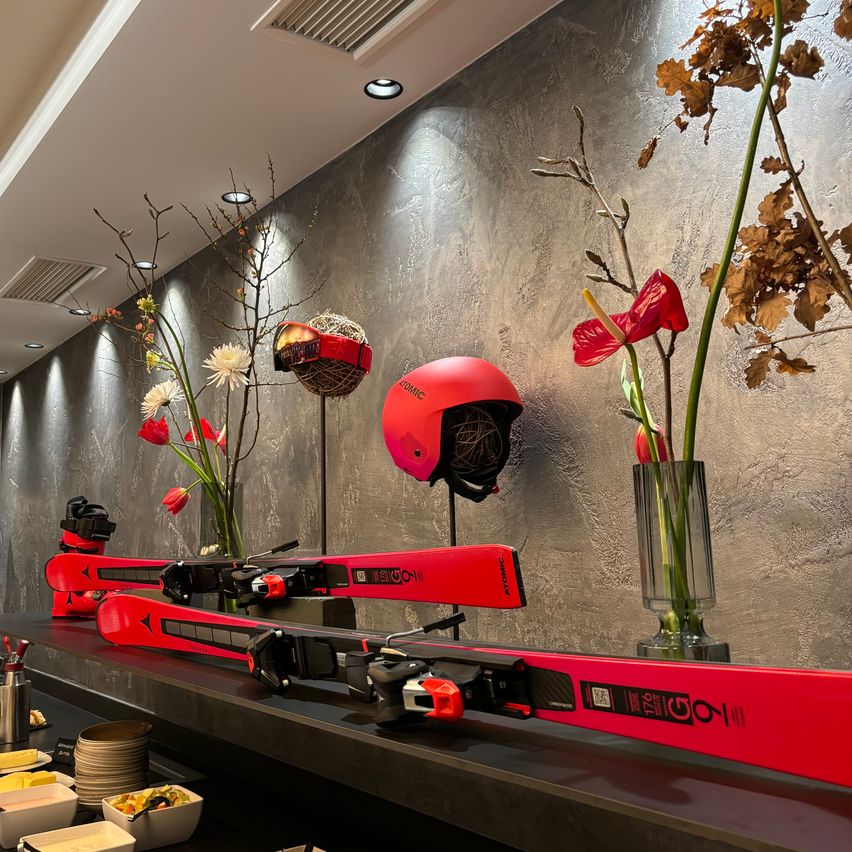Bild enthält, Indoors, Interior Design, Flower, Flower Arrangement, Plant, Helmet, Restaurant, Gun, Weapon