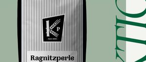 Eine weiße und graue Packung Ragnitzperle Weizenmehl wird vor einem grünen und weißen Hintergrund gezeigt.