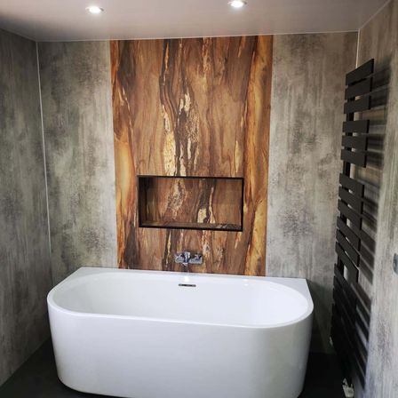 Ein modernes Badezimmer mit einer weißen Badewanne, einer Holzwand, einem eingebauten Regal und einem schwarzen Handtuchhalter.