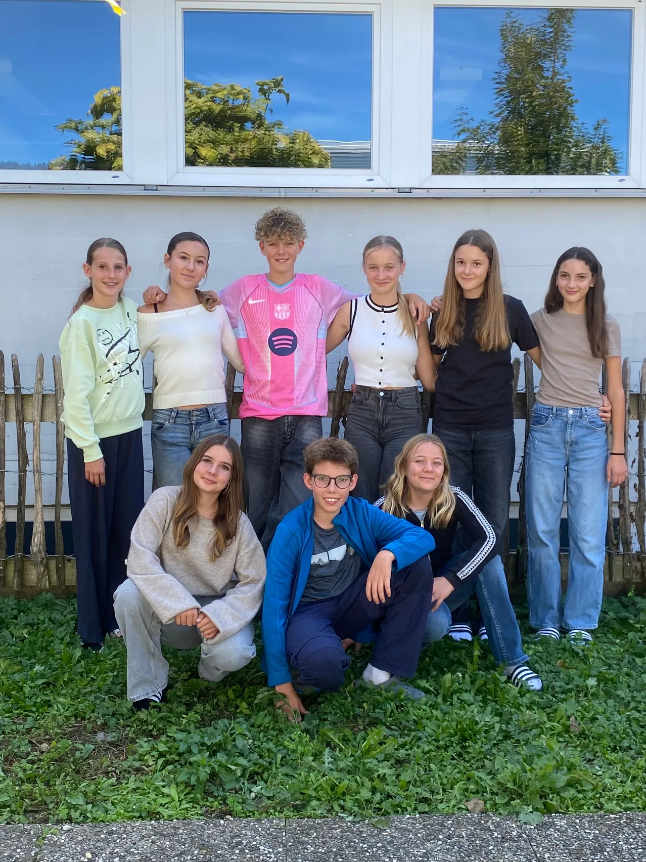 Eine Gruppe junger Menschen posiert für ein Foto vor einem Gebäude.
