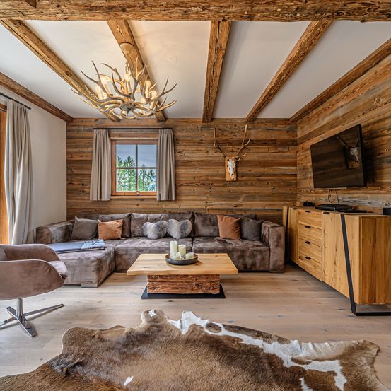 Bild enthält, Indoors, Interior Design, Wood, Wood Panels, Hardwood, Home Decor, Chair, Chandelier, Stained Wood, Living Room