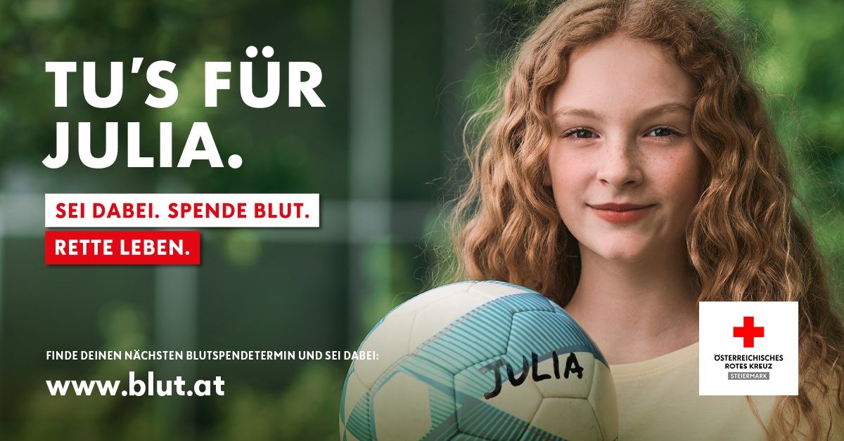 Ein lächelndes Mädchen mit lockigem Haar hält einen Fußball namens Julia in der Hand, vor einem unscharfen grünen Hintergrund. Der Text lautet 'Spende Blut' in Rot.