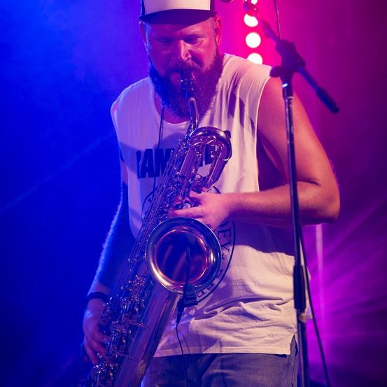 Bild enthält, Lighting, Adult, Male, Man, Person, Concert, Solo Performance, Microphone, Musical Instrument, Hat