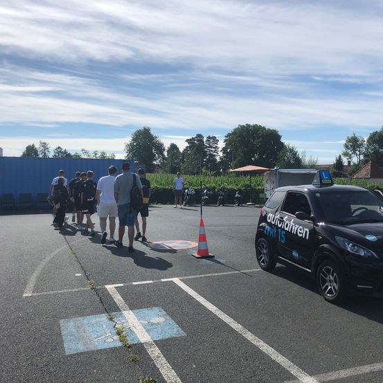 Bild enthält, Person, Car, Transportation, Vehicle, Clothing, Shorts, Machine, Wheel, Footwear, Shoe