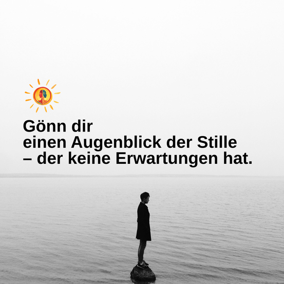 Ein Schwarz-Weiß-Bild einer Person, die auf einem Felsen im Ozean steht. Ein Zitat ist über der Person geschrieben. Das Zitat lautet: 'Gönn dir einen Augenblick der Stille - der keine Erwartungen hat.'
