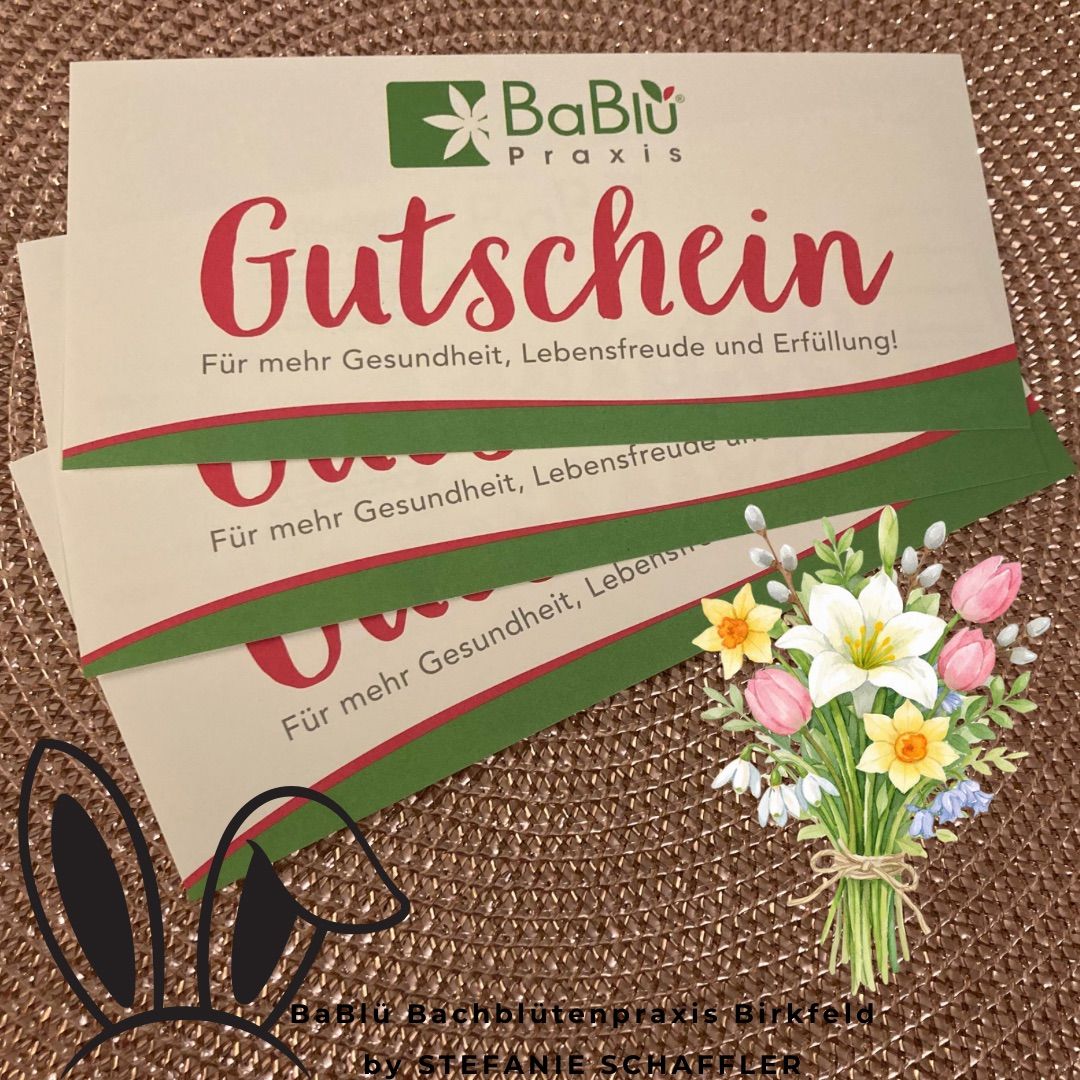 Ein weißer und grüner Gutschein mit einem Blumenstrauß im Vordergrund. Der Gutschein ist in rot und grün mit 'Gutschein' beschriftet, und der Strauß enthält weiße, rosa und gelbe Blumen. Der Hintergrund ist eine natürliche, gewebte Textur.