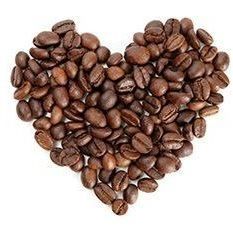 Ein herzförmiger Haufen brauner Kaffeebohnen auf einem weißen Hintergrund.