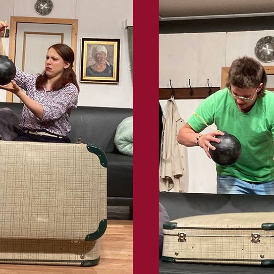 Zwei Personen untersuchen einen alten Koffer, einer mit einem schwarzen Gegenstand, während sie eine Brille und Freizeitkleidung tragen.