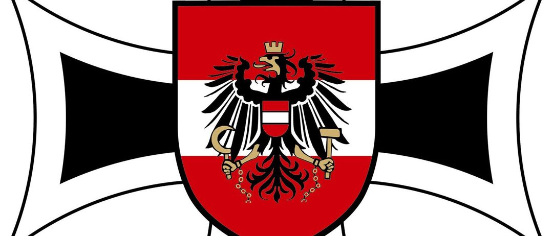 Ein heraldischer Schild mit schwarzem Rand enthält einen zweiköpfigen Adler, der einen Hammer und einen Blitz hält. Der Adler ist rot und weiß mit einer goldenen Krone.
