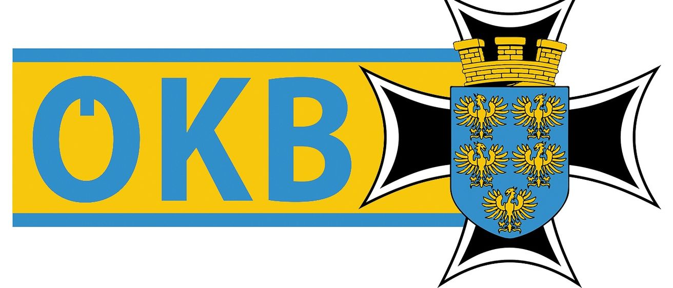 Ein Logo mit 'KB' in Blau auf gelbem Hintergrund, einem schwarzen Eisernen Kreuz und einem Wappen mit einem gelben Adler auf einem blauen Schild.