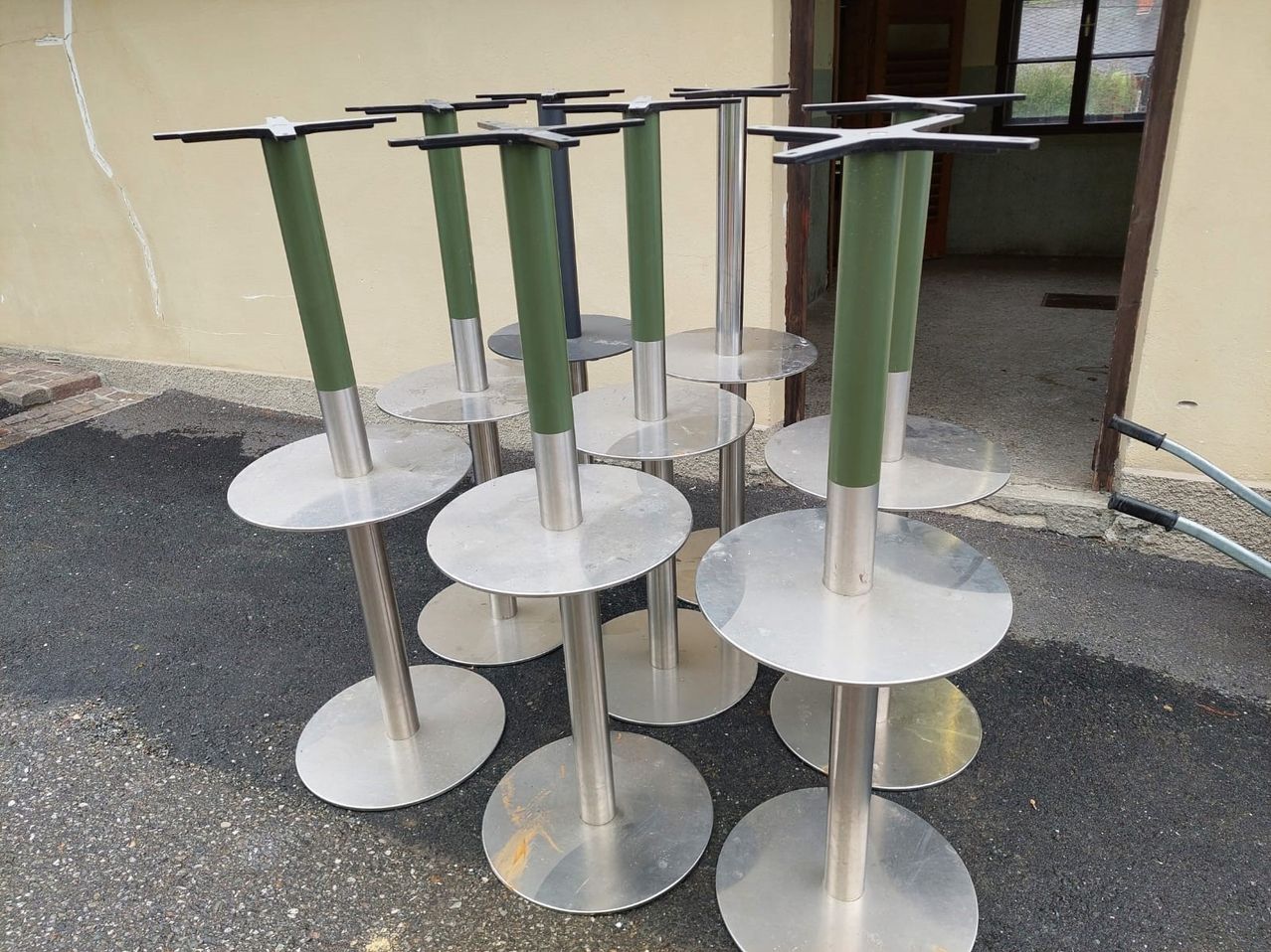 Eine Reihe von Metall- und Grünstühlen ist auf einer Betonfläche in einer Reihe angeordnet.