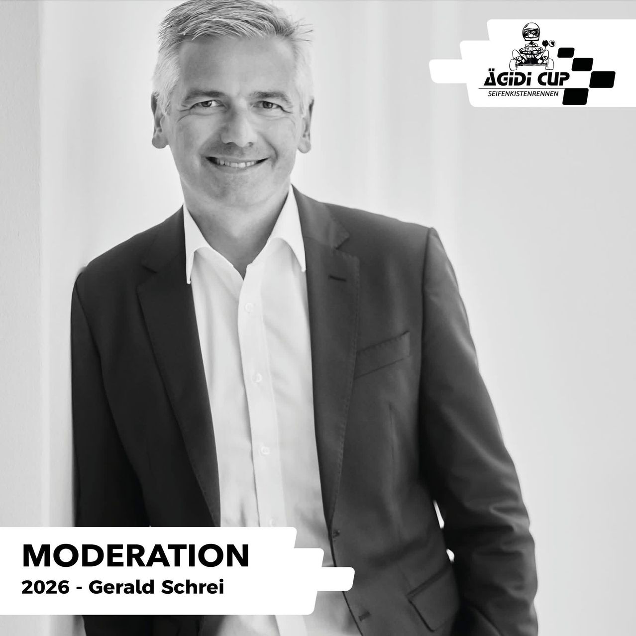 A black and white image of a man in a suit smiling at the camera with the text 'MODERATION 2026 - Gerald Schrei' below.