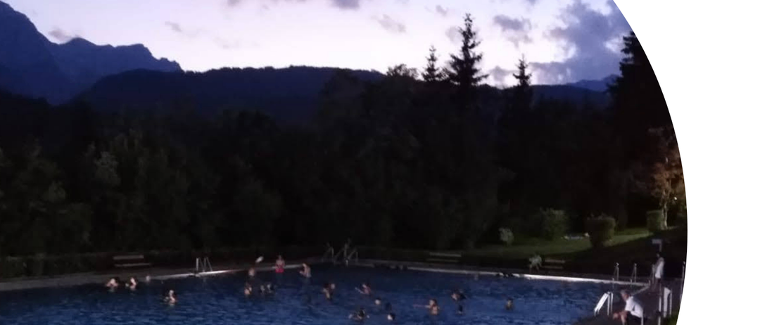 Plakat für Nachtschwimmen im Schwimmbad Pfarwerfen am 18. Juli von 18 bis 22 Uhr. Mehrere Menschen schwimmen im Pool.