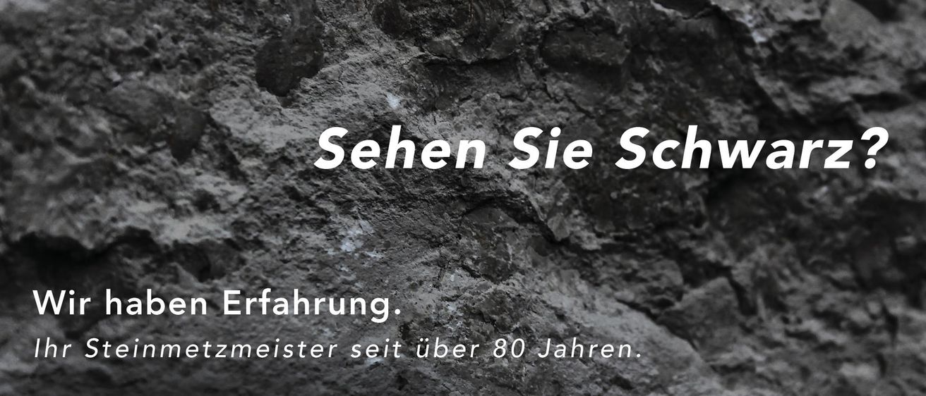 Eine Felswand mit dem Text 'hen Sie Schwarz' und 'g. eit uber 80 Jahren' in weiß auf schwarzem Hintergrund geschrieben.