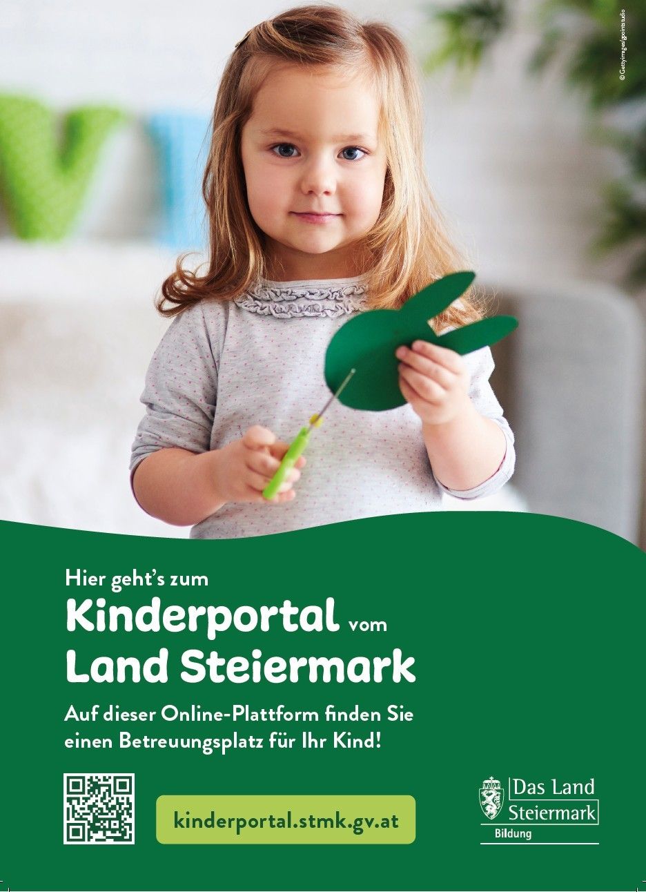 Ein kleines Mädchen hält eine grüne Papierbastelei, möglicherweise ein Osterei, und eine Nadel. Sie schaut nach vorne und hält die Bastelei mit ihren Händen. Der Hintergrund ist unscharf mit einem grünen Buchstaben V und einer weißen Wand.