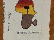Ein Poster zeigt eine stilisierte Karte von Afrika in Form eines Löwen mit einem Sonnenuntergang im Hintergrund. 'HAKAJAYA MATA' steht vertikal links. 'I VIVO ABYMA' steht unten.