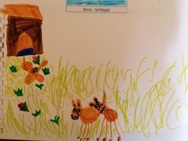 Eine Kinderzeichnung zeigt zwei Rehe in einem Grasfeld. Dahinter steht ein kleines Haus mit einem Baum. Das Bild ist mit 'Nora - Schlaffpi' beschriftet.