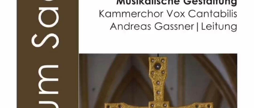 Ereignisposter für die Musikveranstaltung Sacredum Sacrum am 3. April 2026. Ein goldenes Kreuz ist zu sehen, mit einem Buntglasfenster im Hintergrund.