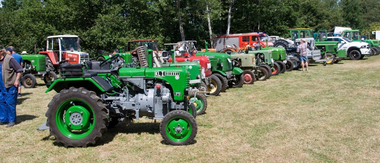Bild enthält, Person, Footwear, Shoe, Tractor, Vehicle, Machine, Wheel, Outdoors, Nature, Car