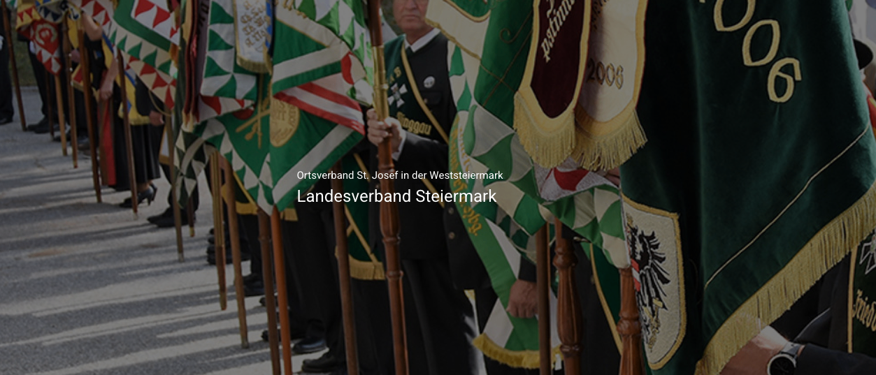 Eine Gruppe von Menschen in Uniform steht in einer Reihe und hält Fahnen mit Metallstangen. Die Fahnen sind grün und weiß. Die Person vorne trägt eine schwarze Uniform mit einem goldenen Emblem.