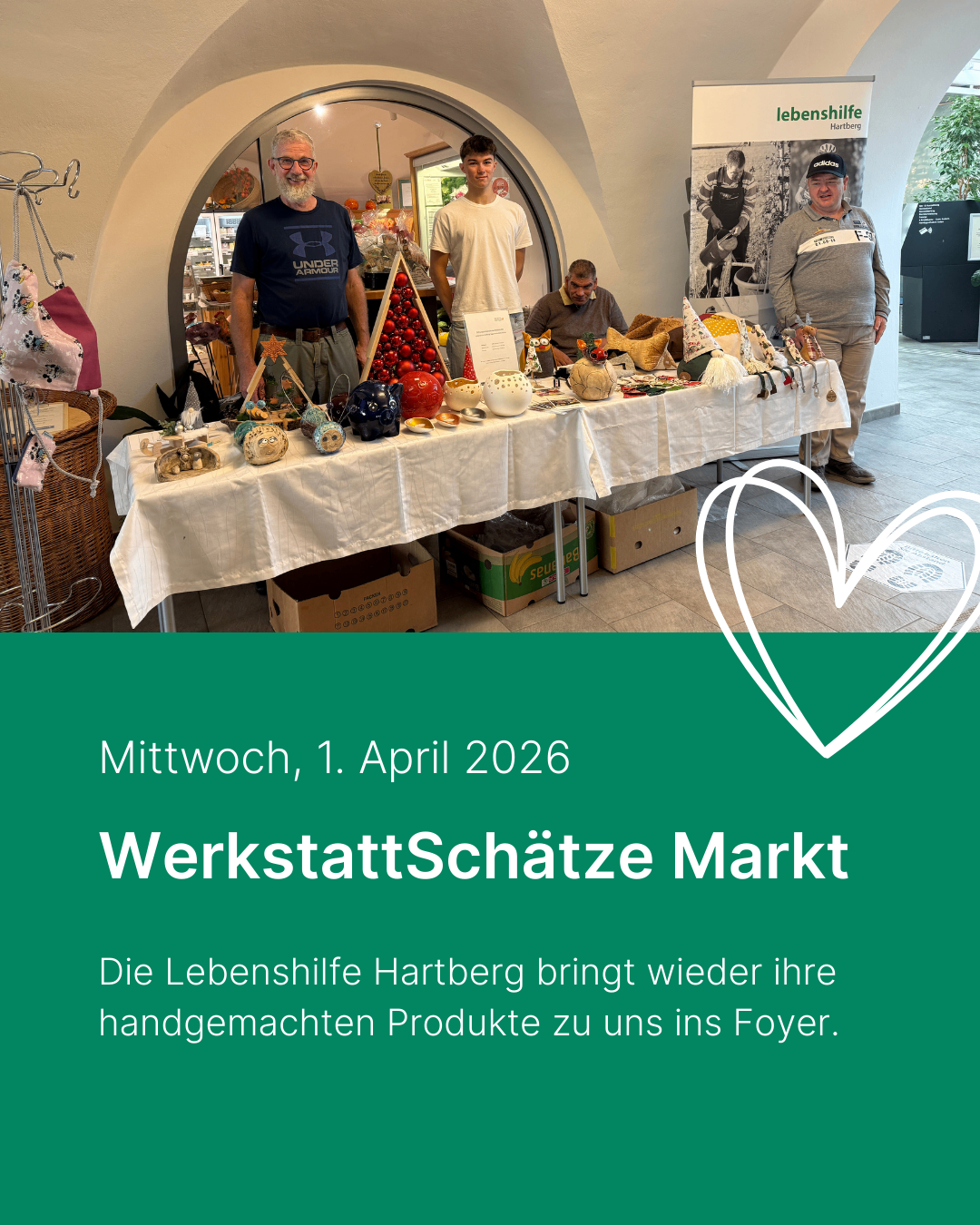 Eine Gruppe von Menschen steht um einen Tisch mit handgemachten Kunstwerken, mit einem Schild, das 'Mittwoch, 1. April 2026 WerkstattSchätze Markt' steht. Die Produkte umfassen Keramik, Ornamente und andere Artikel. Zwei Männer stehen vorne, einer trägt eine Brille.
