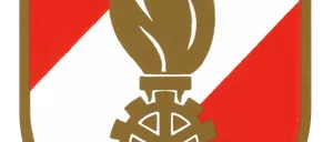 Das Emblem einer Flamme auf einem Zahnrad auf einem Schild mit rotem und weißem Hintergrund.
