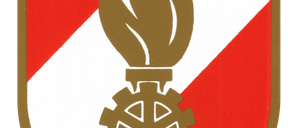 Das Emblem einer Flamme auf einem Zahnrad auf einem Schild mit rotem und weißem Hintergrund.