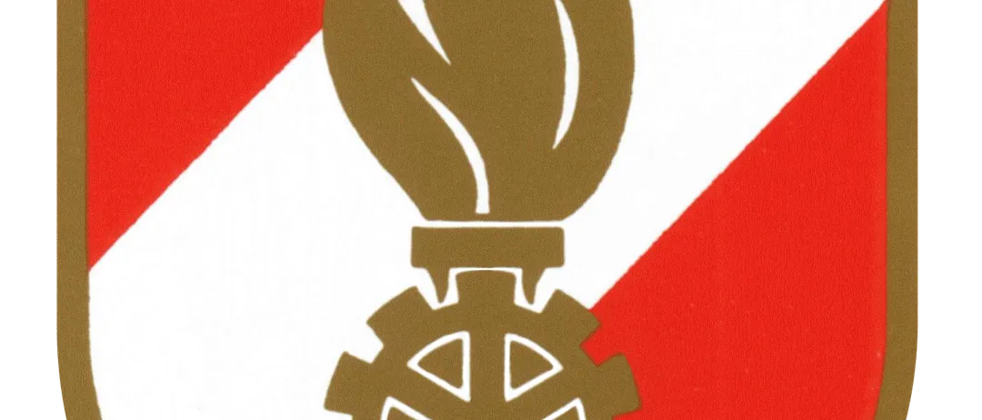 Das Emblem einer Flamme auf einem Zahnrad auf einem Schild mit rotem und weißem Hintergrund.