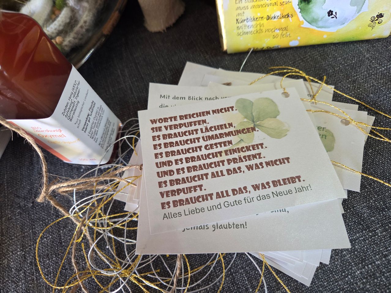 Eine Sammlung von Karten mit einem Blattdesign und einem Zitat: 'Worte reichen nicht. Es braucht Lachen, es braucht Verständnis, es braucht Präsenz.' Verstreut auf einer grauen Oberfläche.