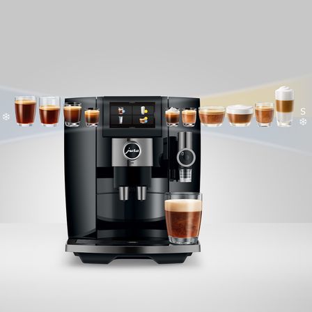 Eine Jura-Kaffeemaschine wird mit mehreren Tassen Kaffee gezeigt. Die Maschine ist schwarz mit einem silbernen Touch und hat ein Touchscreen-Interface. Die Kaffeetassen variieren in Größe und Schaum.
