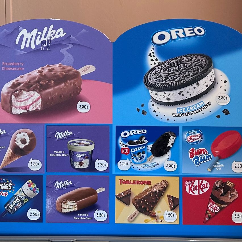 Eine Anzeige verschiedener Eiscreme-Speislichkeiten, darunter Strawberry Cheesecake und Oreo Eiscremestangen, zum Preis von 3,50 Euro. Beinhaltet auch Bum Bum Eiscreme und KitKat Eiscremekegel.