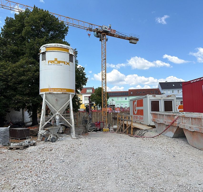 Baustelle mit Silo, Kran und Containern in Österreich