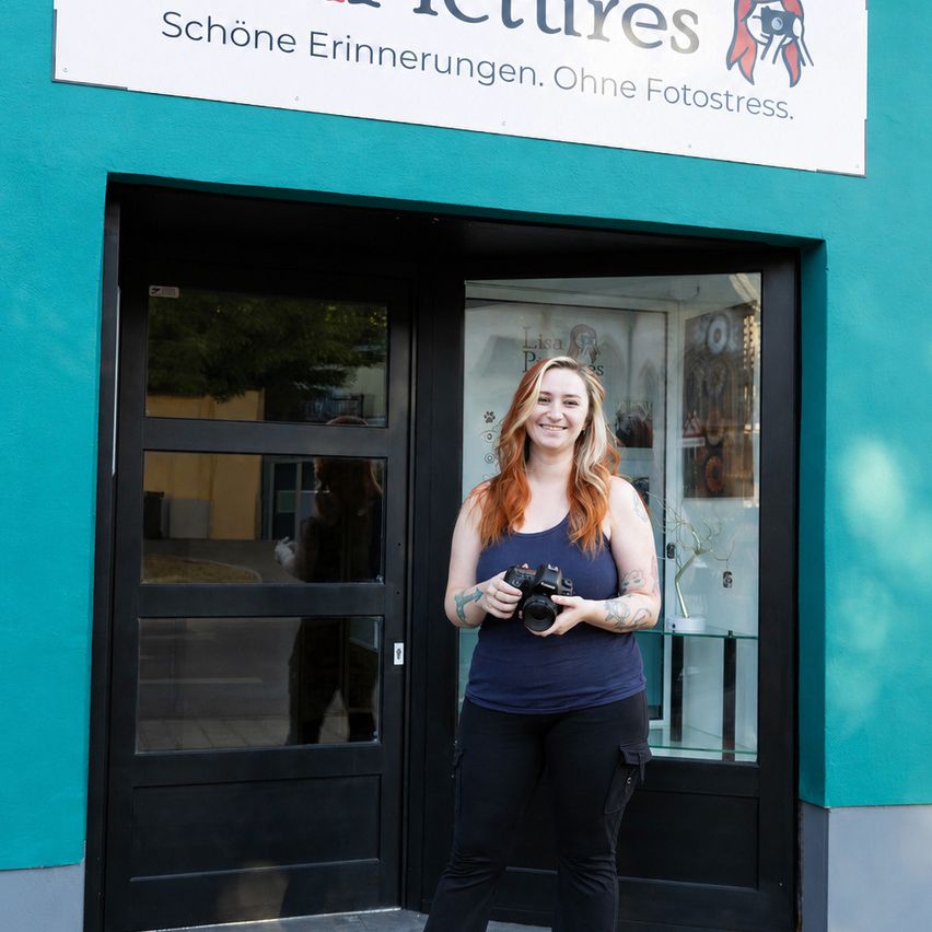 Fotografin Lisa P. mit Kamera vor ihrem Studio in Österreich