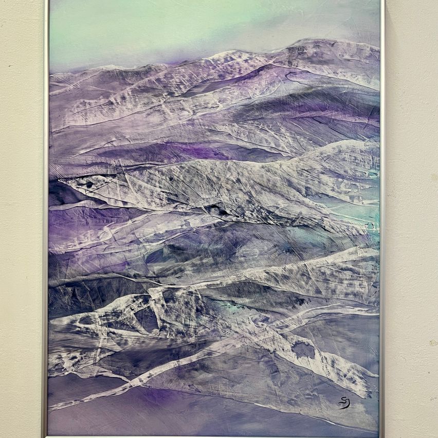 Ein abstraktes Gemälde zeigt eine Berglandschaft mit Tönen von Lila und Blau vor einem grünlichen Himmel. Die Berge sind strukturiert und vielschichtig, was Tiefe verleiht.